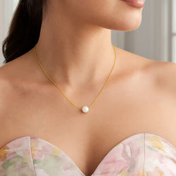 women wearing a gold chain with a single pearl necklace