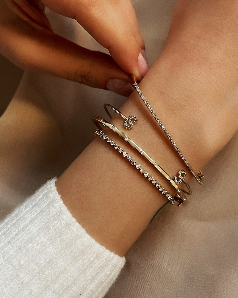 multiple gold bracelets with intricate designs.